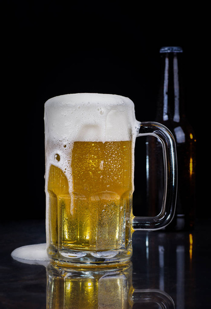 Glass of Cold Beer on a Black Background - Foto, afbeelding