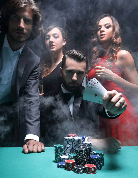 hombres y mujeres concentrados jugando póquer en el casino
 - Foto, imagen
