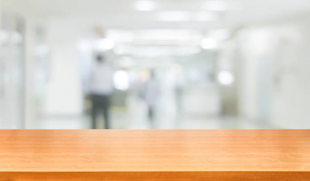 Ξύλινο τραπέζι σε σύγχρονο εσωτερικό νοσοκομείο κτίριο. - Φωτογραφία, εικόνα