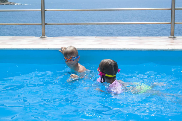 chlapec a dívka plavou v bazénu ve vile - Fotografie, Obrázek