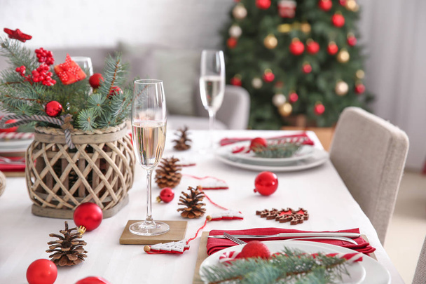 Beautiful table setting with Christmas decorations in living room - Foto, afbeelding
