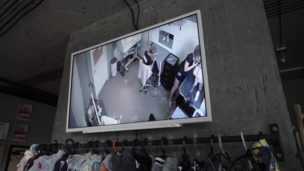 Videobewaking in de verzorgingssalon. Huisdierenwinkel met verzorgingssalon. Scherm met werkende groomers. Cctv. Camera beweegt van links naar rechts. - Video