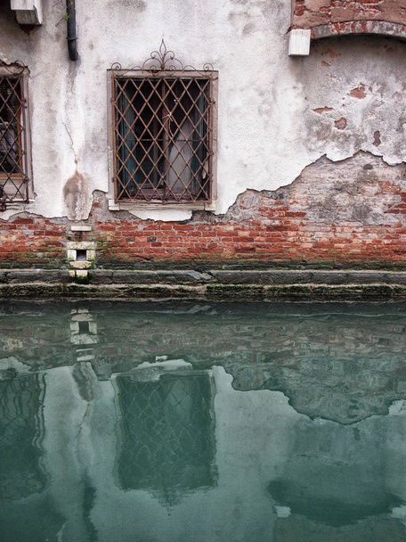 ヴェネツィアの古い崩壊した建物は、窓がCAに反映されています - 写真・画像