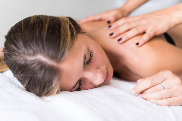 Jeune femme se faisant masser dans un spa
 - Photo, image