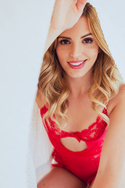 Happy blonde caucasian woman in red lingerie poses in natural li - Photo, Image