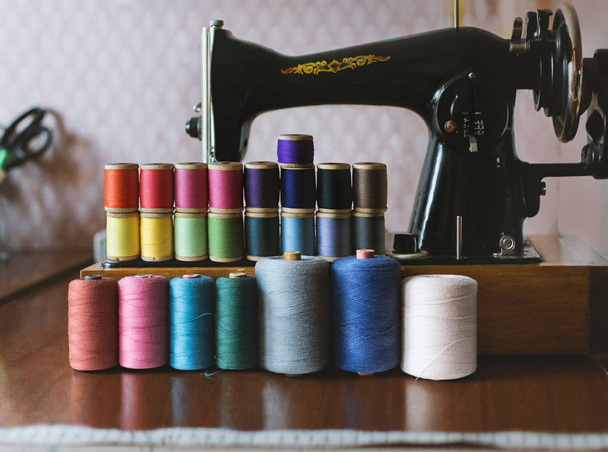 ミシンの背景にヴィンテージ多色縫製糸、選択的浅い焦点、縫製用品 - 写真・画像