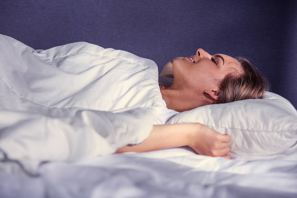 όμορφη νεαρή ξανθιά γυναίκα στον ύπνο στο κρεβάτι - Φωτογραφία, εικόνα