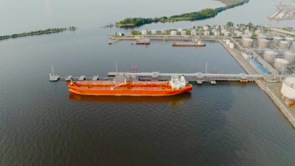Ogromny czerwony statek pancerny morski, z olejem zacumowany do załadunku produktów naftowych i eksport do odległych krajów w całym Oceanie - Materiał filmowy, wideo
