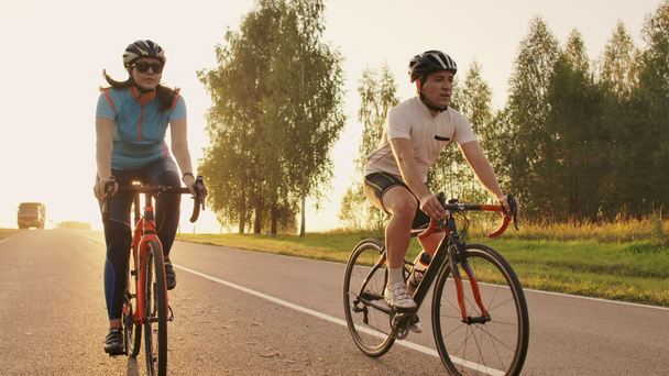 Steadicam colpo di coppia mountain bike in sella su pista ciclabile al tramonto facendo alto
 - Filmati, video