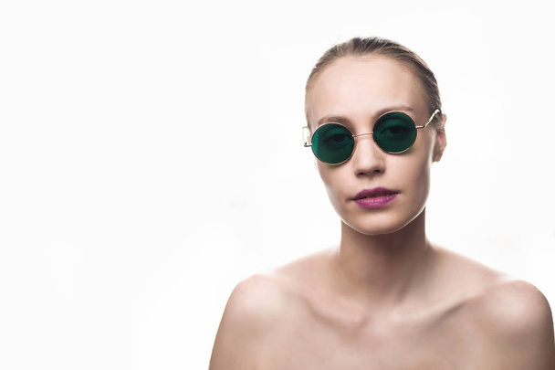 Moda model dziewczyna w zielone okulary przeciwsłoneczne na białym tle patrząc na kamerę. Strzał w Studio. - Zdjęcie, obraz