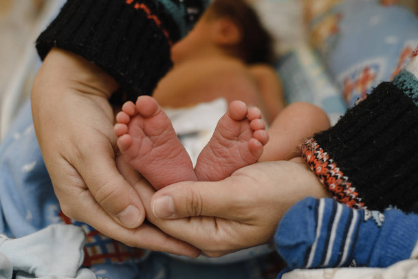 pies de un bebé recién nacido en manos de los padres. El concepto de amor, parto saludable y padres jóvenes felices
. - Foto, Imagen
