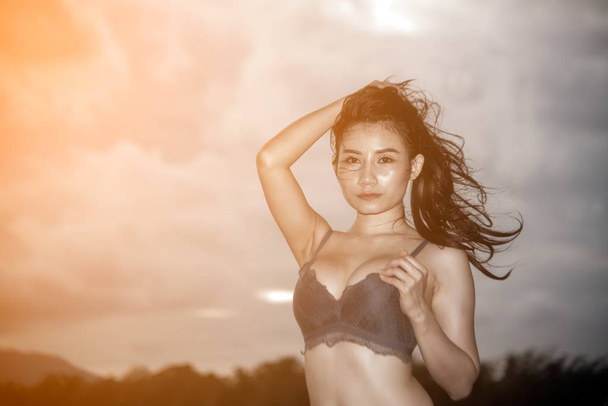 Pretty Asian woman in blue bikini posing on the beach with fun. - Fotografie, Obrázek
