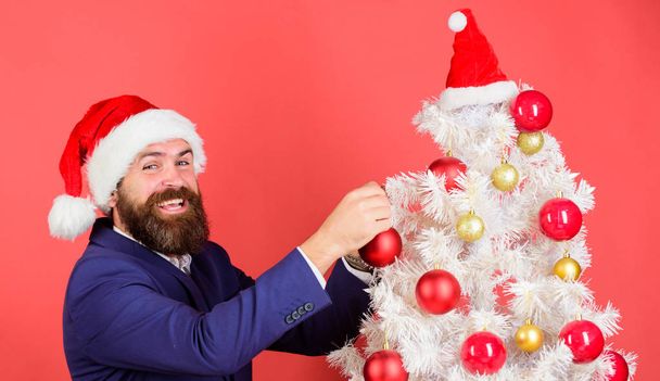 Add magic to holidays. Man bearded wear formal suit and santa hat. Businessman join christmas celebration. Santa hold christmas ball decoration. Merry christmas. Christmas atmosphere spread around - Фото, изображение