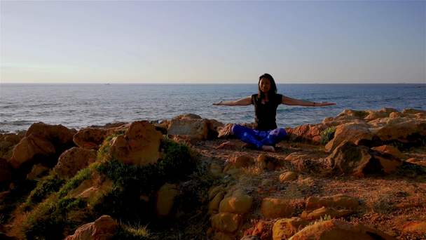 Žena, která pomodá lotosové postoje Hatha jóby před pláží - Záběry, video