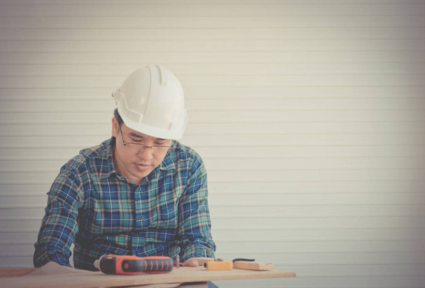 Construction wooden Builder with tools and paper plan on working - Photo, Image
