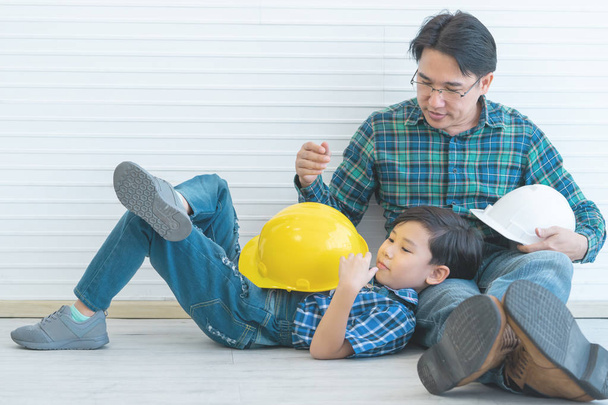 Little builder boy is sitting on Father lap for Father day toget - Photo, Image