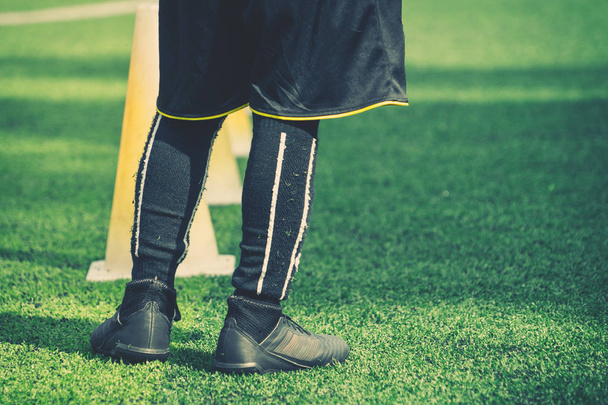 Детские ножки в футбольных сапогах на тренировочном конусе на соке
 - Фото, изображение