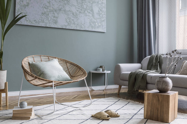 Stylish minimalistic interior of living room with design rattan armchair and elegant accessories. Eucalyptus color of wall. Copy space - Valokuva, kuva