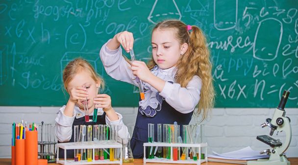 Girls on school chemistry lesson. School laboratory partners. Kids busy with experiment. Chemical analysis and observing reaction. Test tubes with colorful substances. School equipment for laboratory - Zdjęcie, obraz