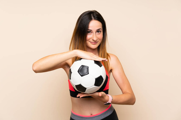 junge Sportlerin mit isoliertem Hintergrund hält einen Fußball in der Hand - Foto, Bild