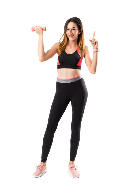 A full-length shot of a sport woman over isolated white background pointing up a great idea - Photo, Image
