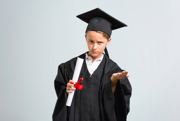Little boy graduating unhappy and frustrated with something. Negative facial expression on grey background - Foto, Imagem