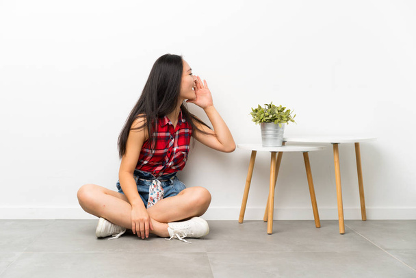 adolescent asiatique fille assis sur l 'plancher crier avec bouche grand ouvert
 - Photo, image
