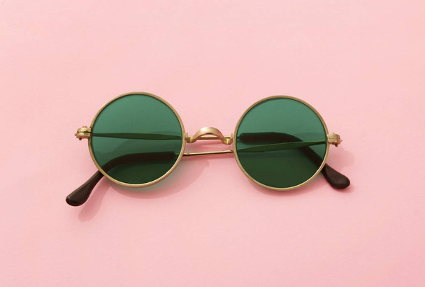 Урожай модні круглі зелені сонцезахисні окуляри на рожевому фоні
 - Фото, зображення