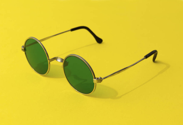 Урожай модні круглі зелені сонцезахисні окуляри на жовтому фоні
 - Фото, зображення