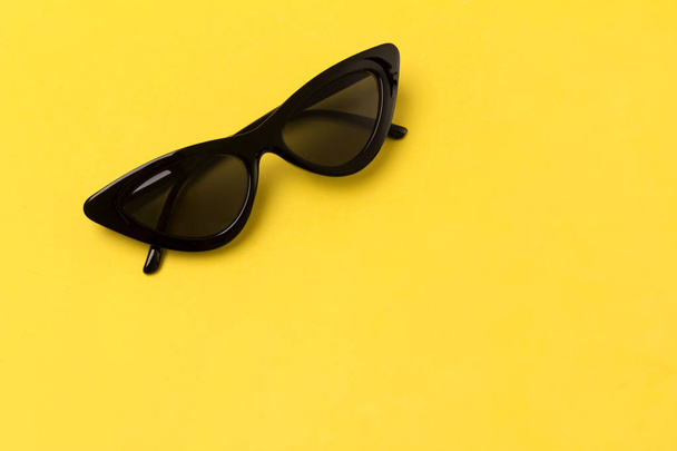 Noir moderne lunettes de soleil à la mode sur fond jaune
. - Photo, image