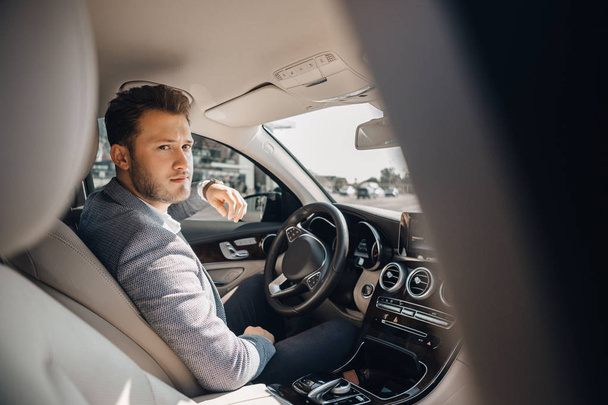 Portrait of a happy handsome businessman driving car. - Fotografie, Obrázek