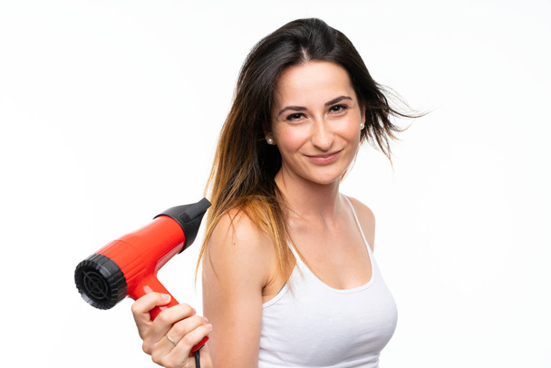 Young woman with hairdryer over isolated background - Photo, Image