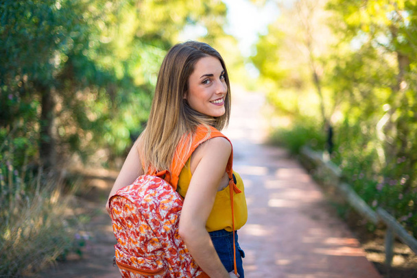 Student young girl with backpack in a park - Foto, Imagen