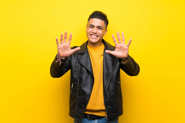 Nuori mies yli eristetty keltainen tausta laskenta kymmenen sormilla
 - Valokuva, kuva