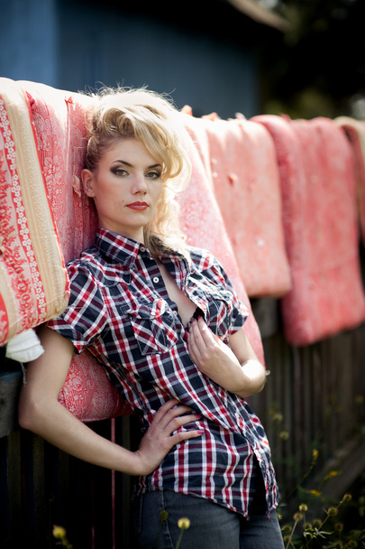 Blonde young woman in cowboy shirt and blue jeans - Фото, зображення