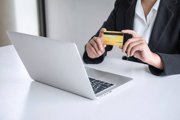 Mujer de negocios con tarjeta de crédito y escribir en el ordenador portátil
 - Foto, Imagen