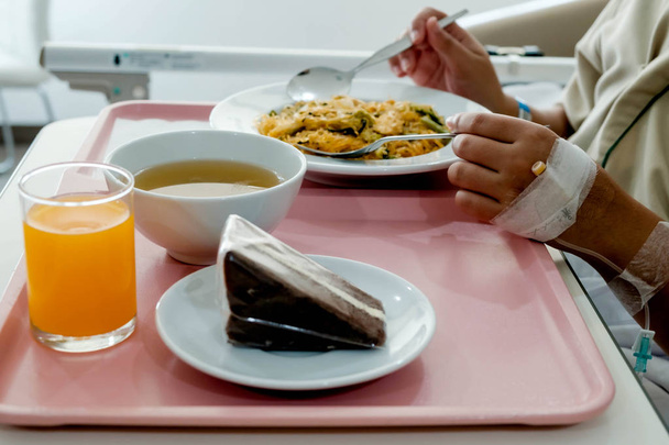 Ο ασθενής στο νοσοκομείο με φαγητό, αναρρώνει στο κρεβάτι. - Φωτογραφία, εικόνα