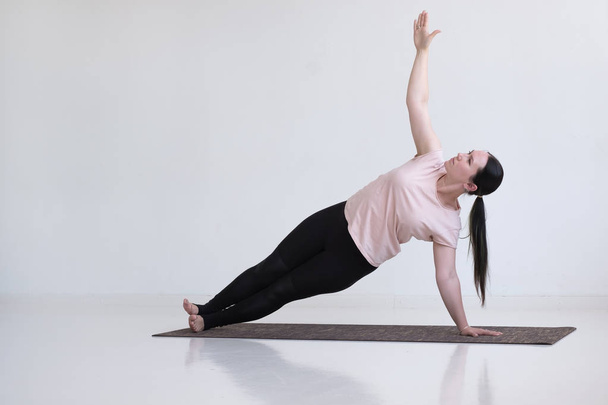 Nő csinál gyakorlatokat, oldalsó Plank Pose, Vasisthasana, jóga Pose - Fotó, kép
