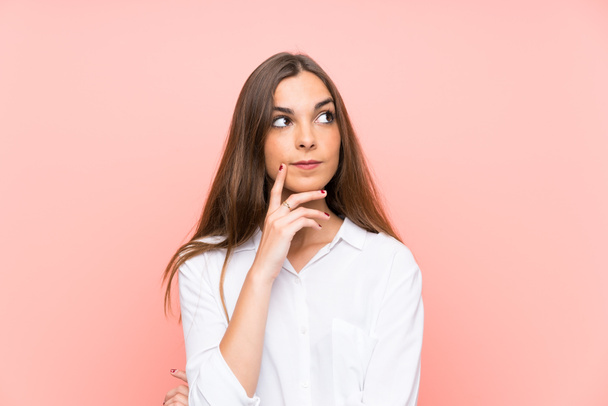 Young woman over isolated pink background thinking an idea - Foto, Bild