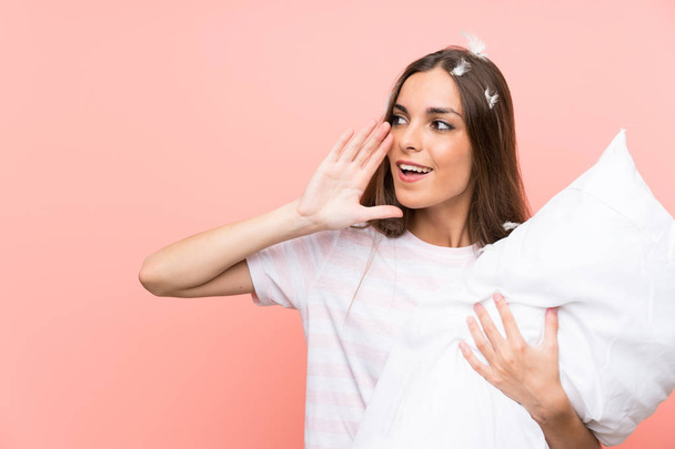 Young woman in pajamas over isolated pink background shouting with mouth wide open - Photo, Image
