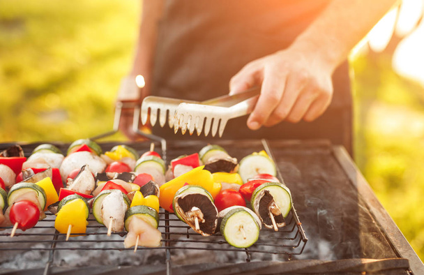 Anonymous man cooking fresh vegetables on grill - Foto, Imagen