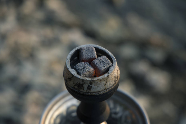 καυτά κάρβουνα με πορτοκαλί φωτισμό στο κάπνισμα σε μη εστιασμένη bokeh φόντο με κενό χώρο για το αντίγραφο ή το κείμενο, χαλάρωση αντίληψη εικόνα  - Φωτογραφία, εικόνα
