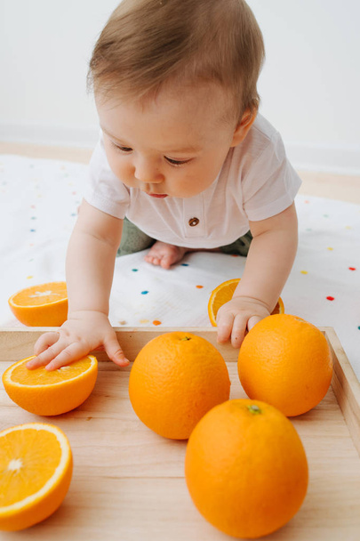 Baby presses an orange, extracting fresh juice - Zdjęcie, obraz