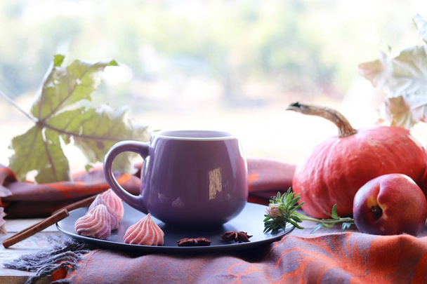 Чашка кофе, безе, тыквы, листья, клетка на фоне окна, концепция домашнего уюта, День благодарения, осенний сезон
 - Фото, изображение