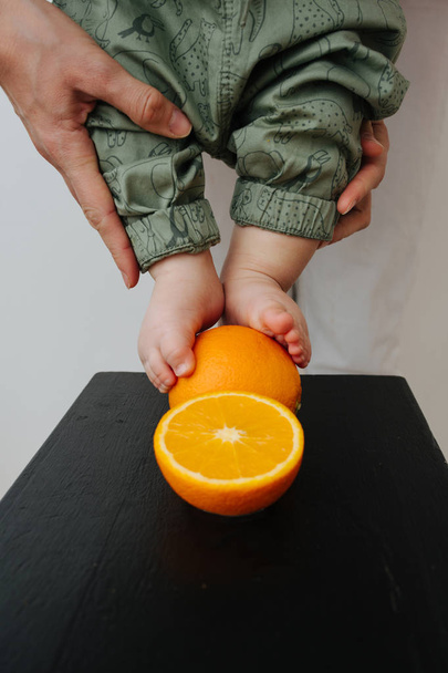 Baby's feet with orange close up photo - Valokuva, kuva