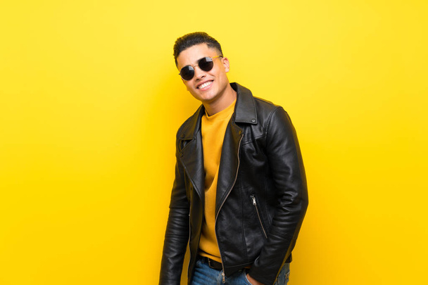 Jeune homme sur fond jaune isolé avec des lunettes et heureux
 - Photo, image