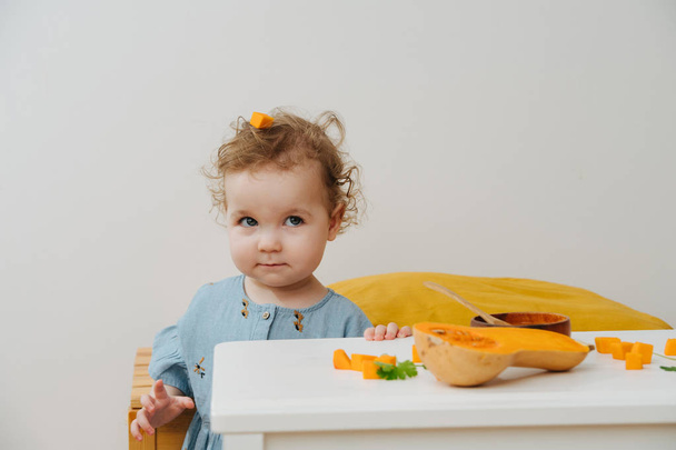 Portrait of a little girl with a piece of pumpkin - Zdjęcie, obraz