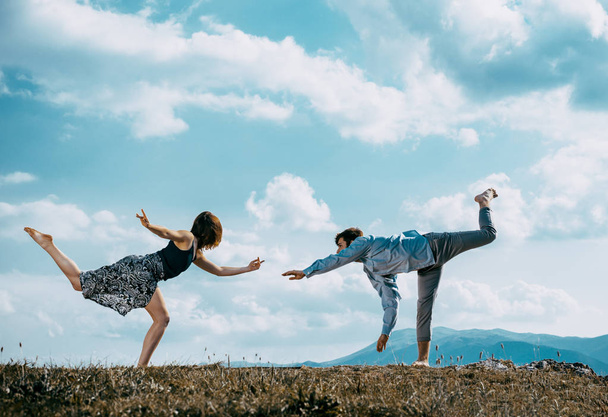 Kaksi modernia tanssijaa harjoittelemassa tanssia kalliolla.
 - Valokuva, kuva