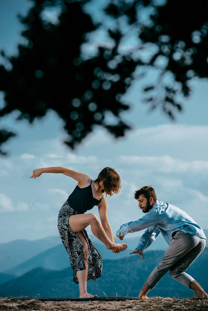  Két ember táncol a kortárs balett színpadán a hegyekben.  - Fotó, kép