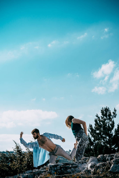 Акробат позирует двум талантливым молодым танцорам на горе
 - Фото, изображение